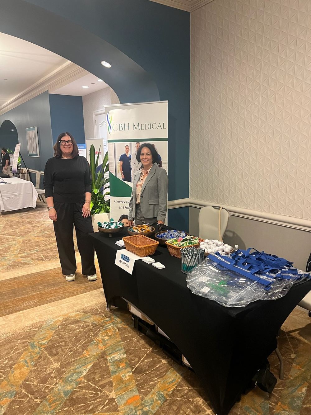 Karen Sugden and Anne White standing at the CBH Medical booth with the CBH banner behind them
